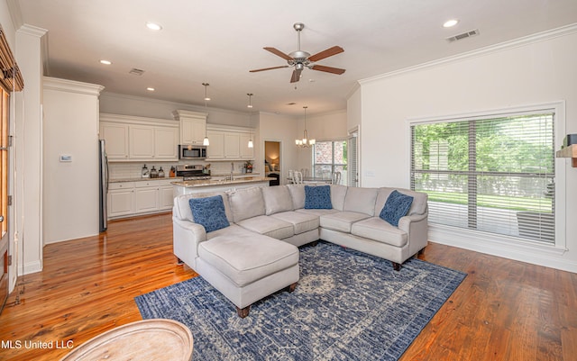 228 Falls Xing, Madison, MS 39110 - living area with a ceiling fan, a chandelier, light wood finished floors, crown molding, and recessed lighting