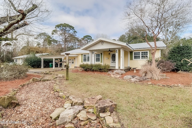 view of front of property featuring metal roof and a front yard