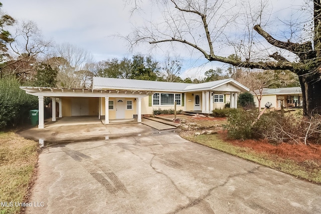 view of front of property with metal roof, driveway, and an attached carport