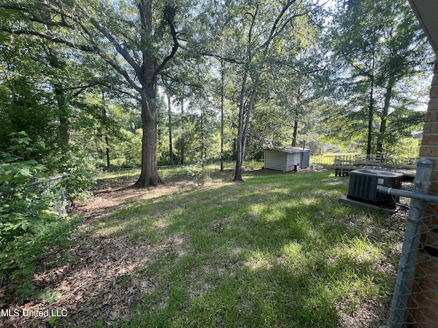 view of yard with central AC and a storage unit