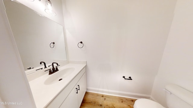 bathroom featuring vanity, toilet, and hardwood / wood-style floors