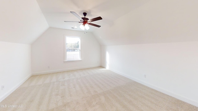 additional living space featuring vaulted ceiling, light carpet, and ceiling fan