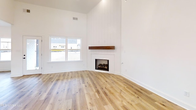 unfurnished living room featuring light hardwood / wood-style floors and high vaulted ceiling