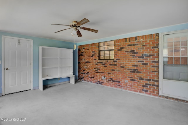 unfurnished bedroom featuring carpet flooring, a ceiling fan, and brick wall