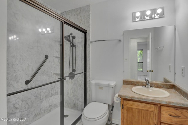 bathroom with toilet, a shower stall, and vanity