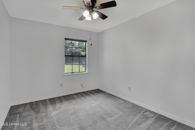 carpeted spare room featuring baseboards and ceiling fan