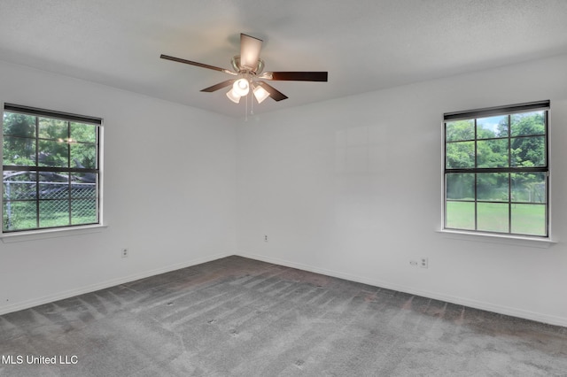 carpeted spare room featuring baseboards, ceiling fan, and a healthy amount of sunlight