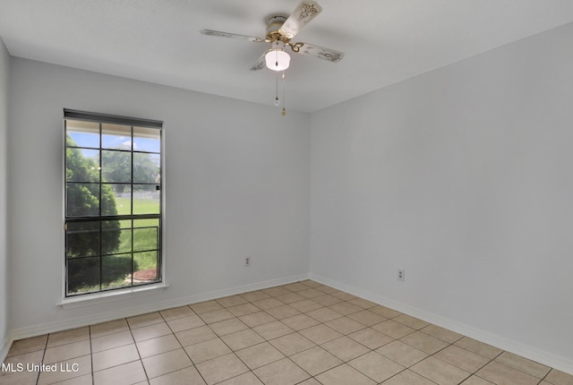 spare room with a ceiling fan and baseboards