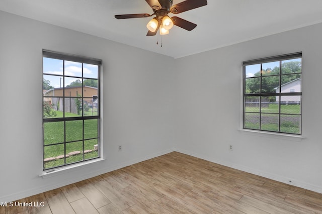 unfurnished room with ceiling fan, baseboards, and light wood-type flooring