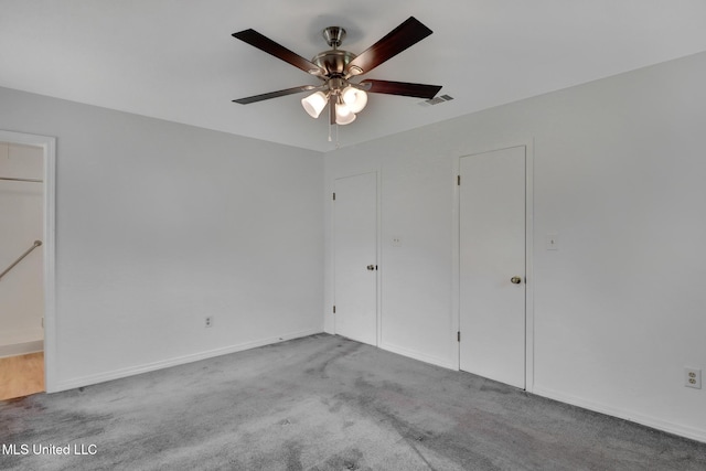 unfurnished bedroom with carpet floors, a ceiling fan, baseboards, and visible vents