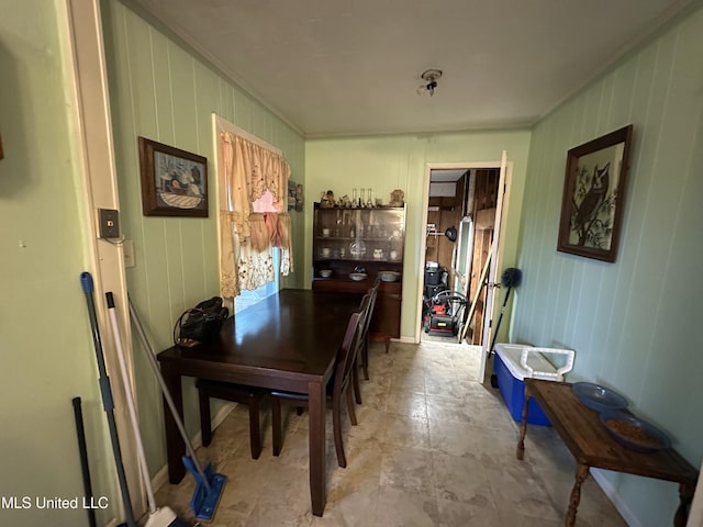 dining room featuring wood walls and ornamental molding