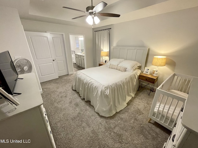 carpeted bedroom with ensuite bathroom and ceiling fan