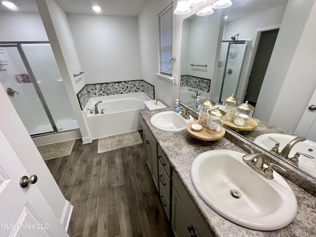 bathroom featuring hardwood / wood-style flooring, vanity, and shower with separate bathtub