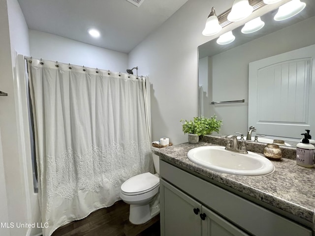 full bathroom featuring vanity, toilet, wood-type flooring, and shower / tub combo