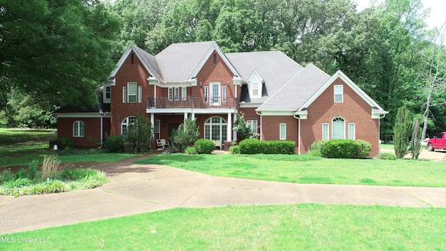 view of front facade with a balcony and a front lawn