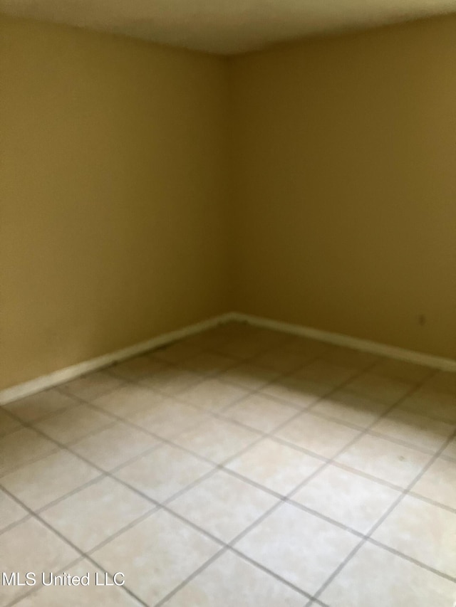 unfurnished room with baseboards