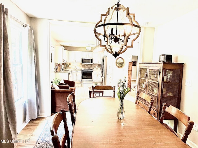 dining area featuring a notable chandelier and light wood finished floors