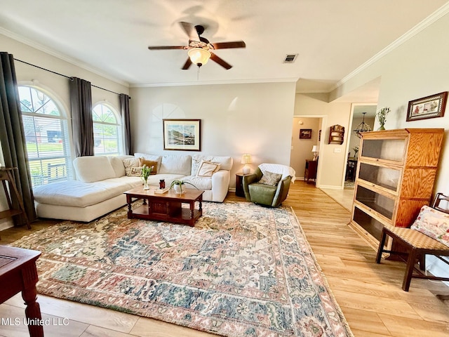 living area with ornamental molding, ceiling fan, and visible vents