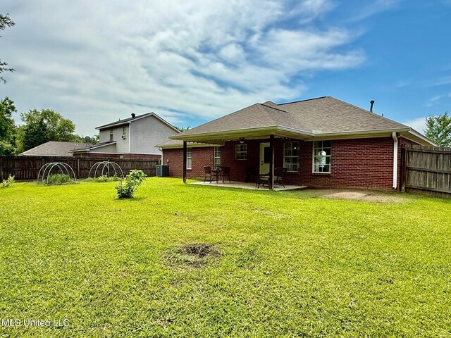 rear view of property featuring a patio, a fenced backyard, and a lawn