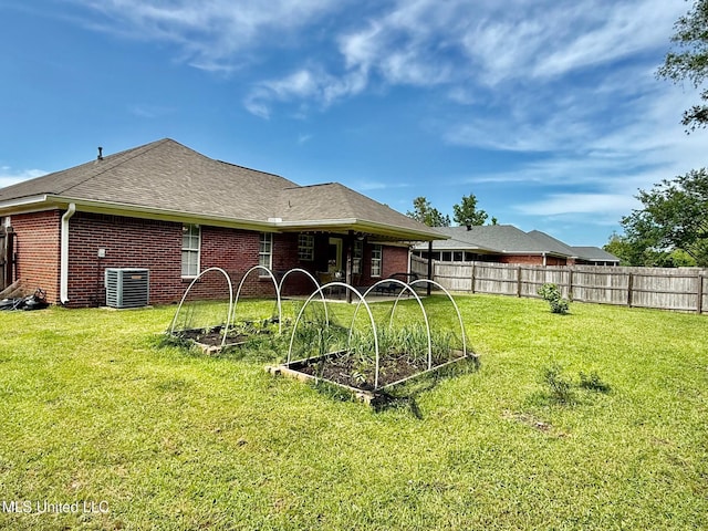 view of yard featuring central air condition unit, fence, and a vegetable garden