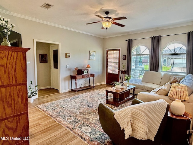 living area featuring ornamental molding, a ceiling fan, light wood-type flooring, and visible vents