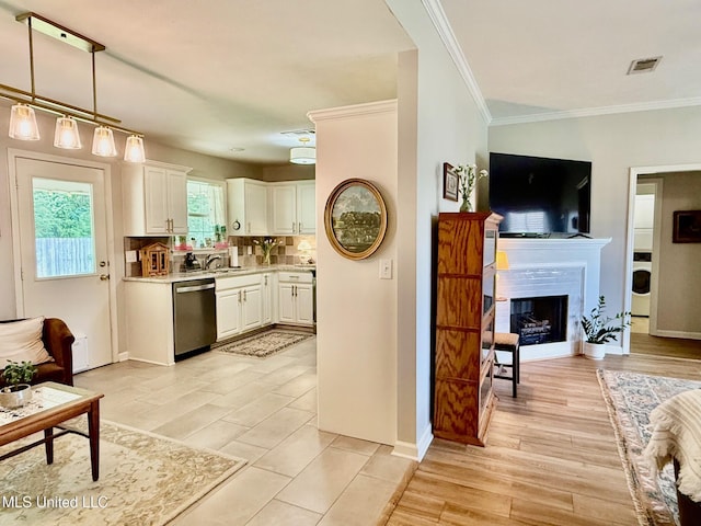 kitchen featuring visible vents, washer / dryer, light countertops, white cabinets, and dishwasher