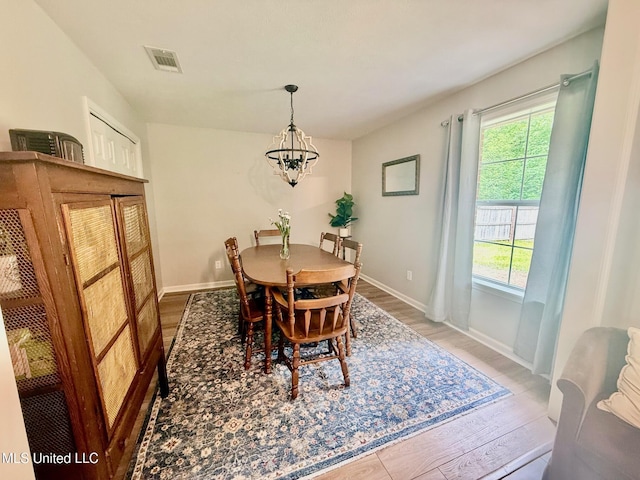 dining space featuring an inviting chandelier, a wealth of natural light, light wood-style floors, and visible vents