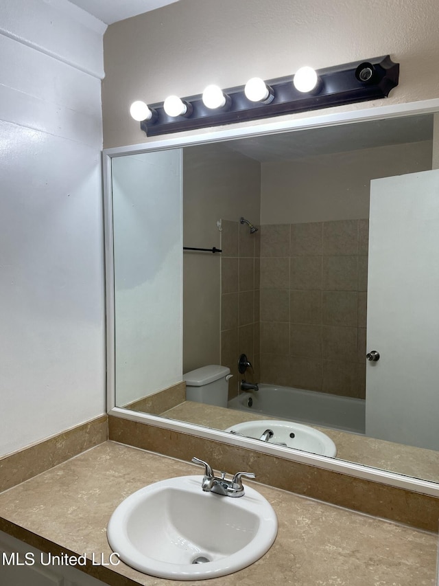 bathroom featuring vanity, toilet, and bathing tub / shower combination