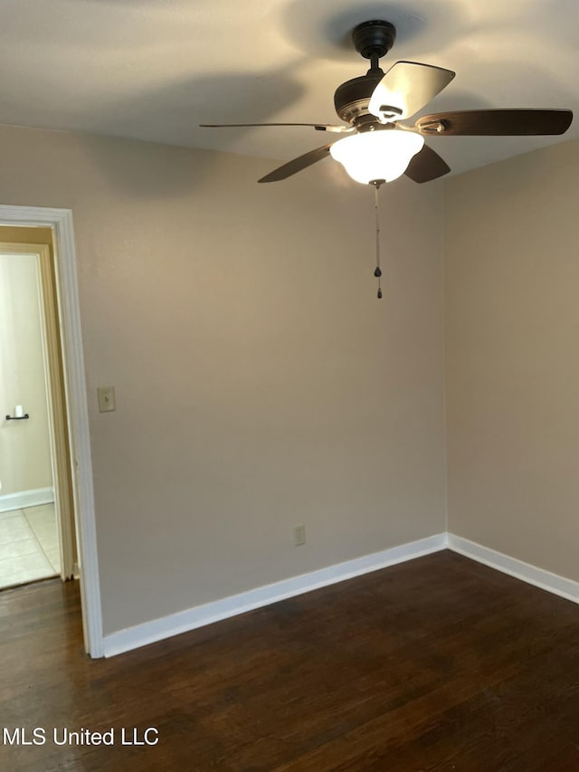 spare room with dark wood-style floors and baseboards