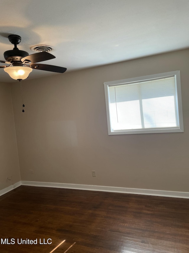 unfurnished room with visible vents, a ceiling fan, baseboards, and dark wood-style flooring