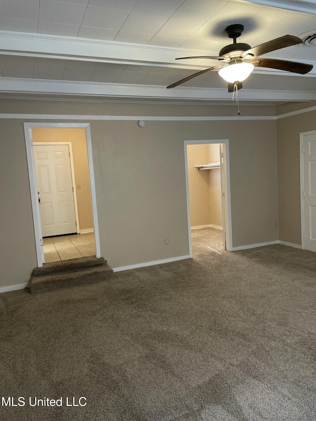 spare room with carpet flooring, baseboards, and ceiling fan