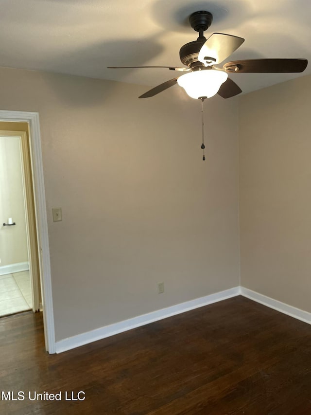 empty room with baseboards and dark wood-style floors