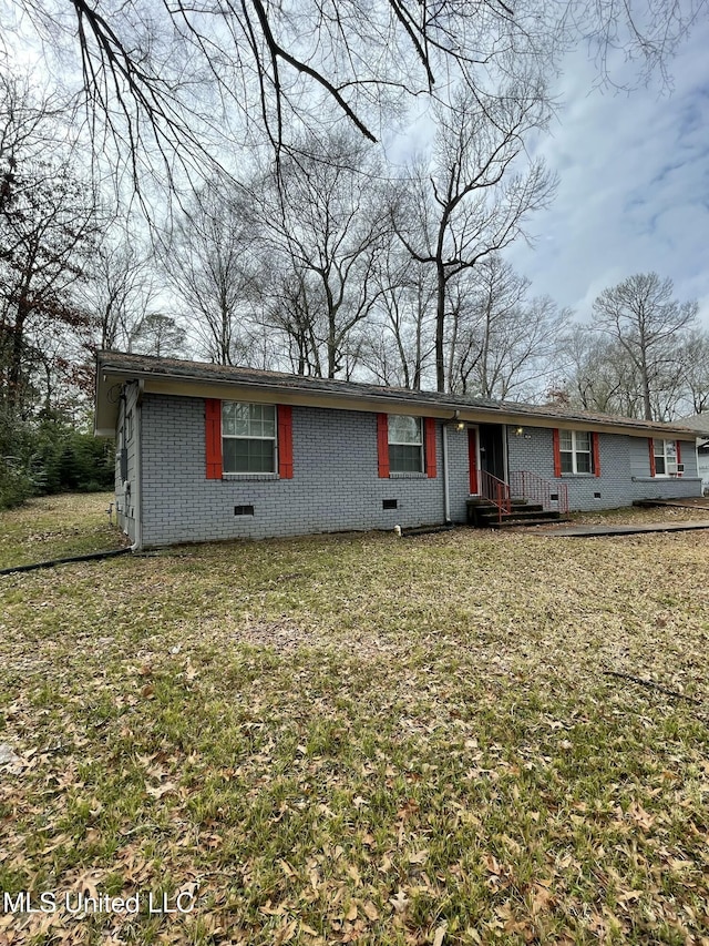 view of front of home featuring a front lawn, brick siding, and crawl space