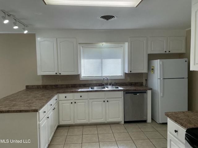 kitchen with dark countertops, visible vents, dishwasher, freestanding refrigerator, and a sink