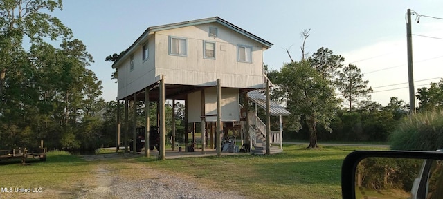4021 Sailfish St, Bay Saint Louis, MS 39520 - back of property featuring stairs, a yard, and dirt driveway