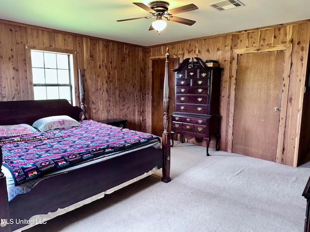 bedroom with wooden walls, carpet floors, and ceiling fan