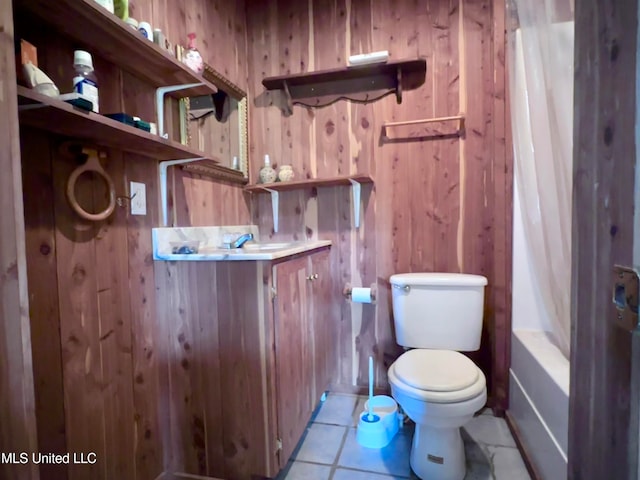 full bathroom featuring toilet, wood walls, vanity, shower / tub combo with curtain, and tile patterned floors