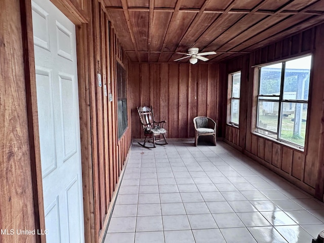 unfurnished room with wood ceiling, light tile patterned floors, wooden walls, and ceiling fan