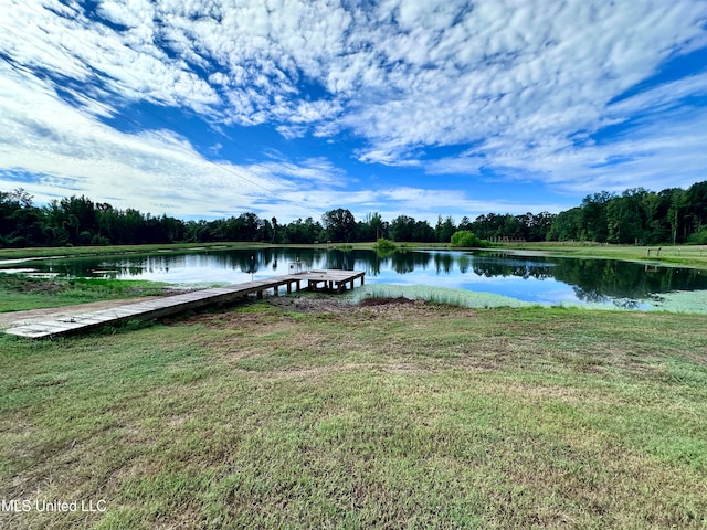 view of dock with a lawn and a water view