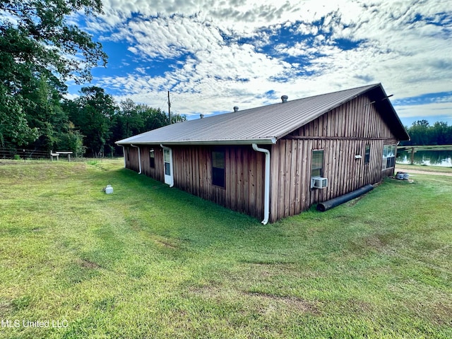 view of side of property with a lawn and a water view