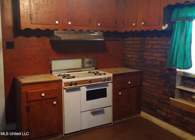 kitchen featuring brick wall, white range, and range hood