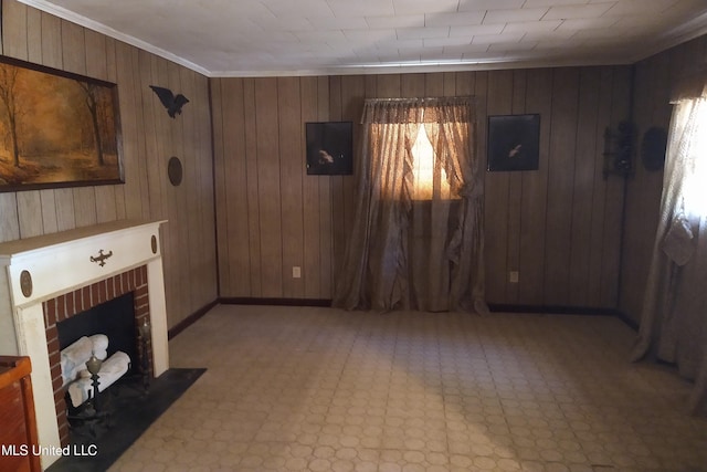 unfurnished living room with wooden walls, a brick fireplace, and crown molding