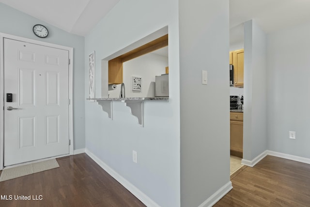 interior space featuring baseboards and dark wood finished floors