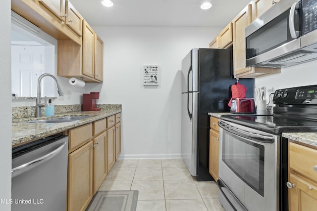 kitchen with light brown cabinets, stainless steel appliances, and a sink