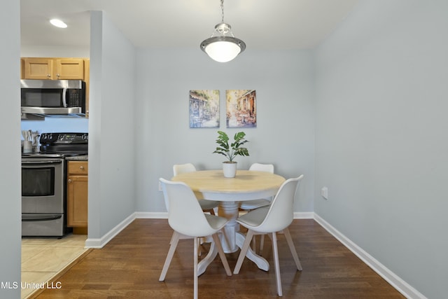 dining area with baseboards and wood finished floors