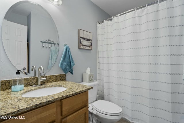 bathroom featuring curtained shower, vanity, and toilet