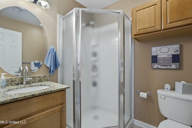 full bath featuring toilet, a shower stall, baseboards, and vanity