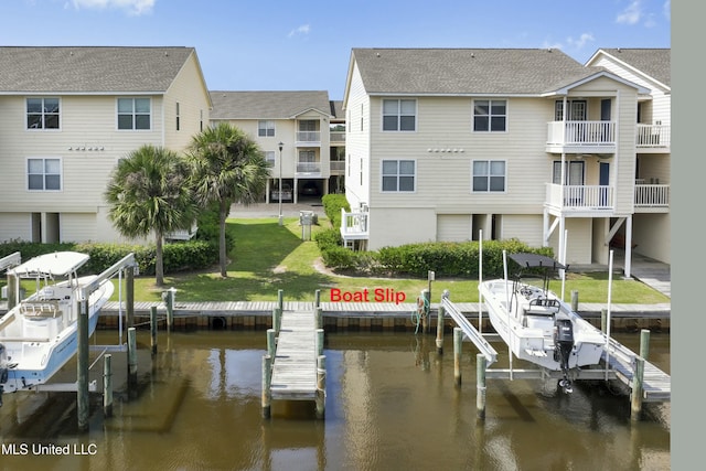 view of dock with a water view, boat lift, a residential view, and a yard