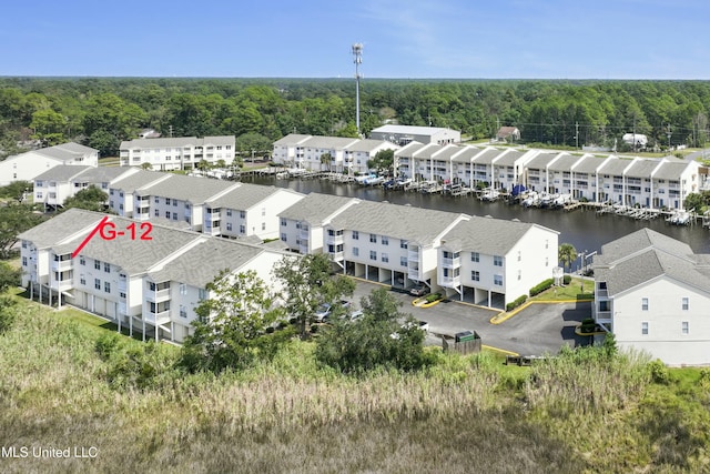 birds eye view of property featuring a water view, a forest view, and a residential view