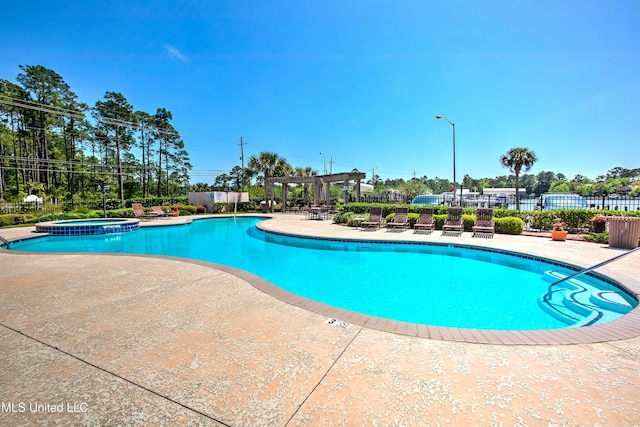 view of pool featuring a patio area, fence, a pool with connected hot tub, and a pergola